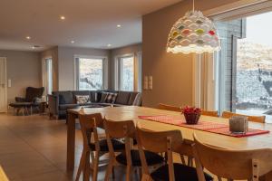 a dining room and living room with a table and chairs at Intersporthytta Sogndal in Sogndal +4 photos