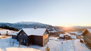 a group of houses in the snow with the sunset at Intersporthytta Sogndal in Sogndal