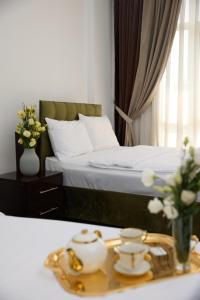 a bedroom with a bed and a tray with flowers at Чынар Отель in Änew
