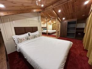 a bedroom with a large white bed in a room at The Riviera Hotel Pahalgam in Pahalgām