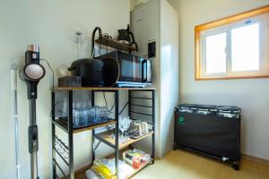 a kitchen with a shelf with a microwave at バンビホーム青森中央 in Aomori +15 photos