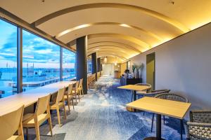 a row of tables and chairs in a room with windows at Hotel Global View Urawa in Saitama