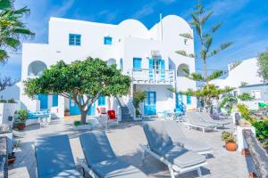 a view of a white building with chairs and trees at Salvatore Caldera Suites in Imerovigli