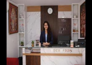 a woman is sitting at a reception desk at Hotel Bindram Palace - Rishikesh in Rishīkesh
