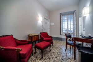 a waiting room with red chairs and a desk at Hotel Simon in Seville