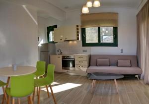 a living room with a couch and a table and chairs at Andriotis Rooms & Houses in Skála Loutrón