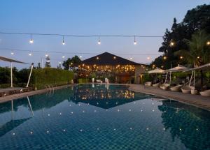 a swimming pool in front of a building with lights at JSI Resort Megamendung in Puncak