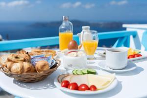 a table with breakfast foods and drinks on a table at Salvatore Caldera Suites in Imerovigli