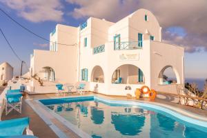 a villa with a swimming pool in front of a house at Salvatore Caldera Suites in Imerovigli