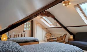a attic bedroom with two beds and a window at Cottage Les Séquoias de l'Oust Clim mobile in Malestroit