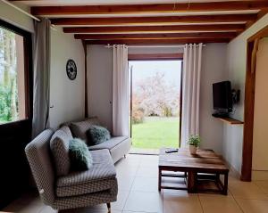 a living room with a couch and a table at Cottage Les Séquoias de l'Oust Clim mobile in Malestroit