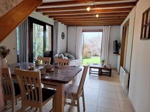 a dining room with a table and chairs and a living room at Cottage Les Séquoias de l'Oust Clim mobile in Malestroit