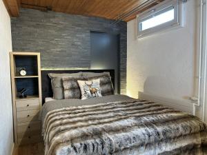 a bedroom with a bed and a brick wall at Chalet Waldhüsli - CharmingStay in Quarten