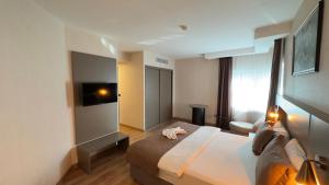 a hotel room with a bed and a television at Adana Time Business Hotel in Adana