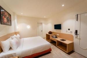 a hotel room with a large bed and a desk at Hotel Benchmark Premier in Indore