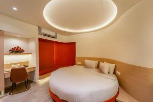 a bedroom with a bed and a desk and a bed sidx sidx sidx at Hotel Benchmark Premier in Indore