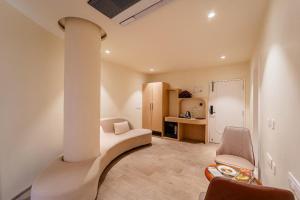 a living room with a couch and a chair at Hotel Benchmark Premier in Indore