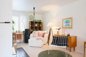 a living room with a white couch and a chair at Villa Rimppari täydellinen porukalle 9 hlö puusauna nuotiopaikka ja parkki in Oulu