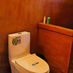 a bathroom with a white toilet in a room at Akha Hill House in Ban Doi Hang