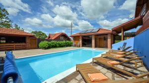 a swimming pool with lounge chairs next to a house at Villa Nina by Villas Guide in Ludbreg