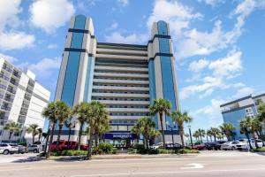 a large building with palm trees in front of it at Spacious Beach Condo Double Suite for Couples Getaway in Myrtle Beach