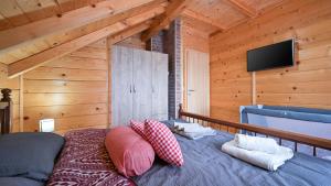 a bedroom with a bed with pillows and a flat screen tv at Villa Nina by Villas Guide in Ludbreg