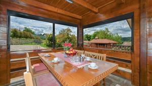 a dining room with a table and large windows at Villa Nina by Villas Guide in Ludbreg