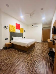 a bedroom with a bed and a wooden floor at hotelindriya in Noida