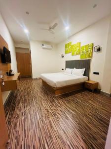 a bedroom with a bed and a wooden floor at hotelindriya in Noida