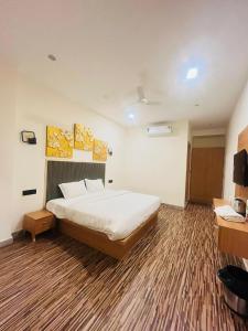 a hotel room with a bed and a desk at hotelindriya in Noida