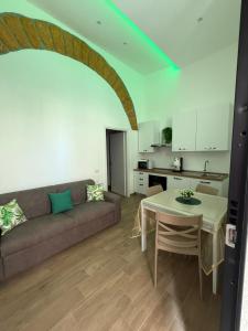 a living room with a couch and a table and a kitchen at Luxury Royal House 3 in Palermo