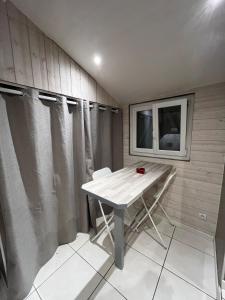 a small room with a table and a window at Maisonnette chaleureuse, paisible & proche tram in Blanquefort +5 photos