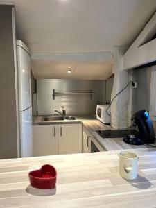 a kitchen with a red bowl on top of a table at Maisonnette chaleureuse, paisible & proche tram in Blanquefort