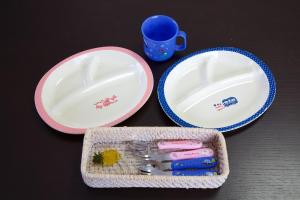 two plates and a container with tooth brushes and a cup at はなハウス 401 in Ginowan