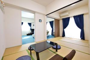 a living room with a table and a couch at はなハウス 401 in Ginowan