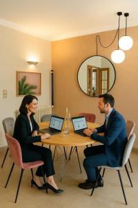two people sitting at a table with laptops at Cit'Hotel Logis De Brou, Bourg en Bresse RENOVE EN 2026 in Bourg-en-Bresse
