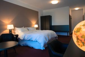 a hotel room with a bed and a table and chairs at Hotel Cvilín in Krnov