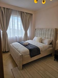 a bedroom with a bed with a large window at Ideal homes in Gatunga