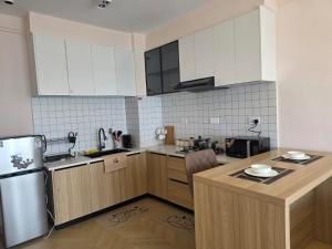 a kitchen with white cabinets and a wooden counter top at Ideal homes in Gatunga