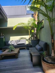 a patio with couches and potted plants and a table at Napier Apartment Ahuriri in Napier