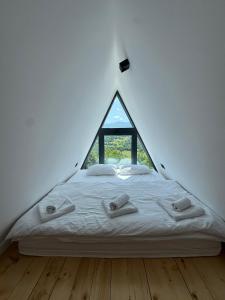 a bedroom with a bed with a triangular window at Kucica na Brdu in Brda