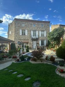 a large stone building with a garden in front of it at Le clos fleuri in Saint-Gervazy