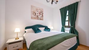 a bedroom with a bed with green curtains and a window at Dvori Perdedaj by Villas Guide in Beretinec +34 photos
