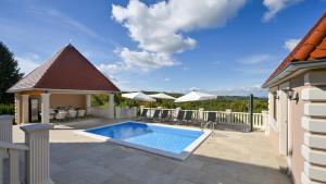 a swimming pool with a gazebo and a patio at Dvori Perdedaj by Villas Guide in Beretinec