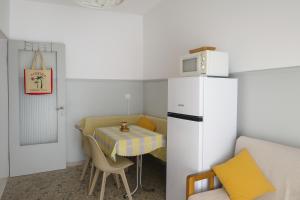 a small kitchen with a table and a refrigerator at Balcony Sea Hanioti Stay in Hanioti