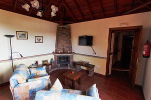 sala de estar con sofá y chimenea en Casa Rural Hermana "by henrypole home", en Breña