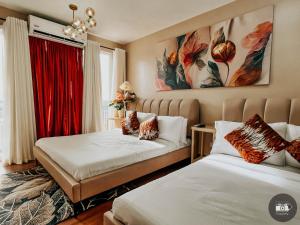 a bedroom with two beds and a red curtain at Modern Studion with 2 Queen Bed in Sampong +36 photos