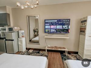 a living room with a tv on the wall at Modern Studion with 2 Queen Bed in Sampong