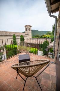 a chair and a table on a patio with a view at Hôtel de Mirmande in Mirmande
