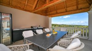 a dining room with a table and chairs on a balcony at Dvori Perdedaj by Villas Guide in Beretinec